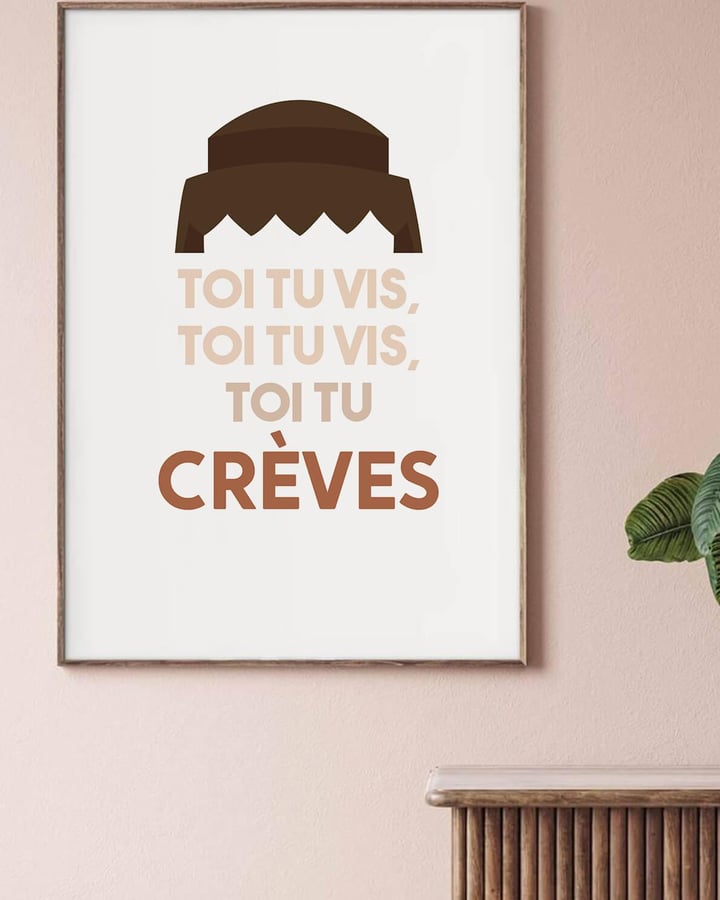 L’affiche de la réplique de Dewey dans un cadre en bois, sur un mur rose poudré, près d’une plante