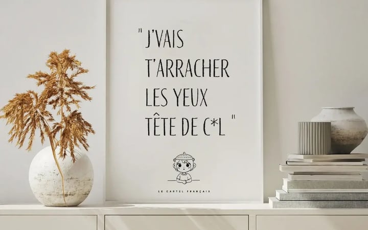Affiche J’vais t’arracher les yeux encadrée sur un buffet blanc