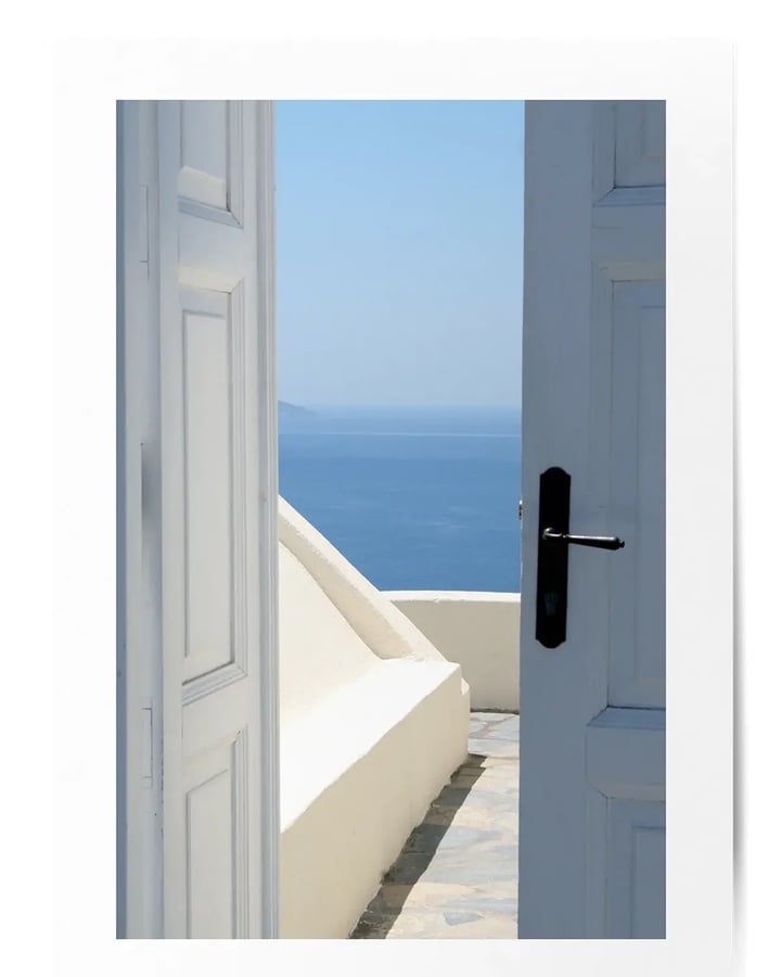 L’affiche Porte vue sur mer posée à plat : la porte blanche ouverte sur la terrasse et la mer