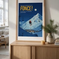 Affiche vas y fonce dans un cadre en chene pose sur un buffet