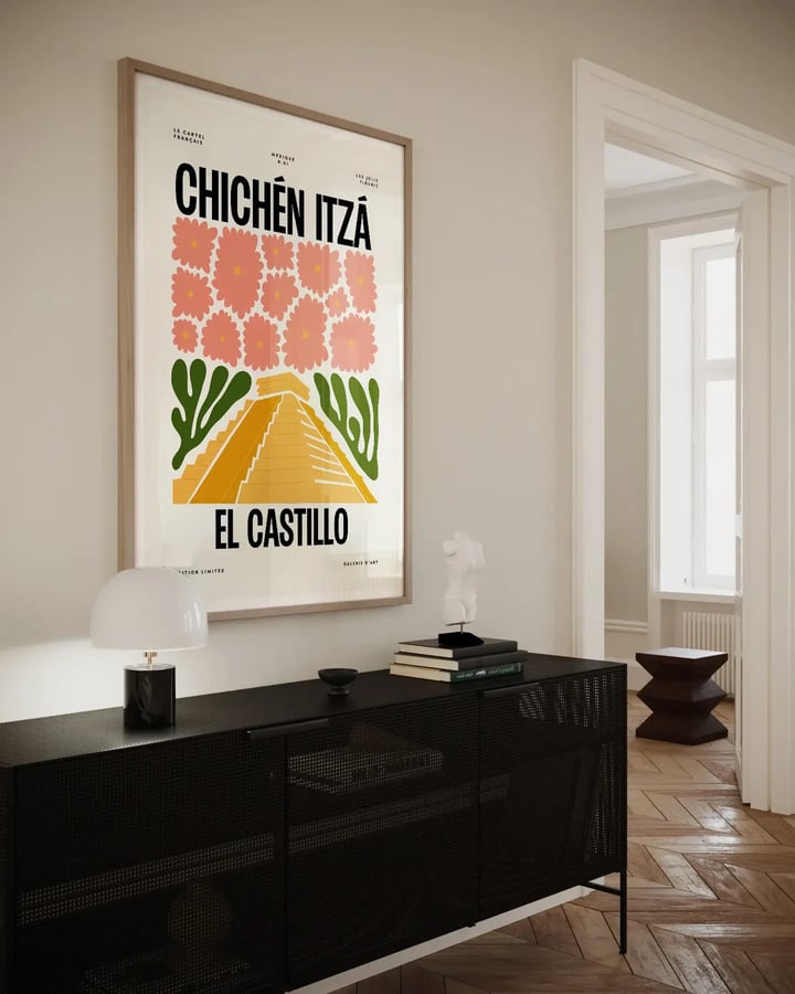 L’affiche Chichén Itzá encadrée au-dessus d’un buffet noir, près d’une porte ouverte sur une pièce lumineuse