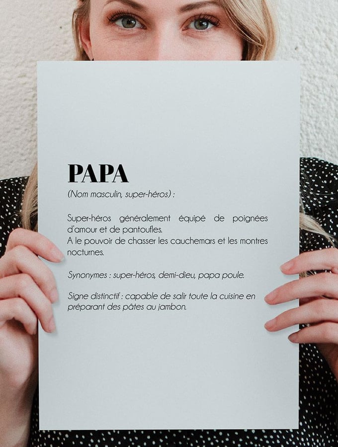 L’affiche Définition Papa poule tenue devant un visage, le titre PAPA et la définition bien lisibles